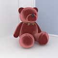 Red Velvet Teddy Bear With Green Bow Tie Sitting On White Surface Near Window