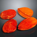 Four Fresh Red and Orange Textured Almonds on Dark Background