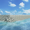 Rock Seawall Extending Along Calm Ocean Under Blue Sky With White Clouds