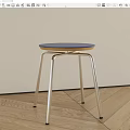 Modern Minimalist Stool With Blue Round Seat And Silver Metal Cross Legs On Wooden Floor