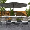 Outdoor Wicker Table And Chair Set With Large Umbrella And Green Plants