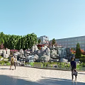 Scenic Park Landscape With Rock Waterfall Stone Path Green Trees And Pedestrians Walking