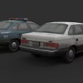 Old Police Car With 911 Logo And White Sedan Parked Together