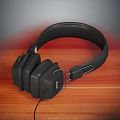 Black Over Ear Headphones on Wooden Tabletop with Comfortable Headband and Wired Connection