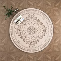 Round Beige Rug with Floral Pattern on Wooden Geometric Floor with Green Plant and Book