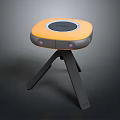 Sleek Orange And Gray Electronic Device With Circular Top And Tripod Stand Design
