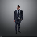 Man in Blue Suit With Glasses Standing With Hands in Pockets Against Gray Background