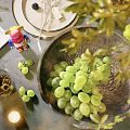 Potted Plant Decor On Table With Green Grapes In Bowl And Leaves