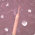 Elegant Pink Electric Toothbrush with Flower Petals on Pink Water Surface