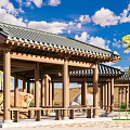 Traditional Open Wooden Pavilion Featuring Green Tiled Roof And Stone Surroundings