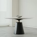 Round Marble Top Dining Table With Black Conical Base Gold Accent And Decorative Bird Ornament
