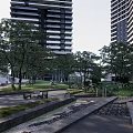 Modern Residential Entrance Gate Surrounded by High-Rise Buildings Trees Lawn Paths and Leisure Chairs