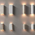 Eight Wall Lamps In Different Shapes White Beige On Grey Wall With Warm Glowing Light