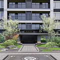 Modern Residential Building Exterior With Lush Greenery Trees Shrubs And Stone Pathways