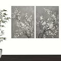 Two Gray Background Paintings With White Flower Branches And Green Plant Near White Shelf