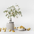 Decorative Ceramic Vase with Plant and Bowl Holding Yellow Fruits on Pedestal and Scattered Fruits