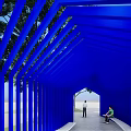 Blue Pavilion Structure With Trees And Grass In Park Where Two People Are Sitting
