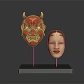 Red Demon And Light Colored Human Face Costume Masks On Black Base With Golden Stands