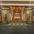 Buddhist Temple Interior Featuring Central Buddha Statue Flanking Figures Mural Paintings And Prayer Lamps