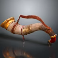 Decorative Horn Shaped Household Item With Golden Accents And Red Leather Strap