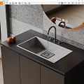 Stylish Kitchen Sink with Faucet Running Water on Black Countertop Near Oranges and Gray Wall
