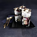 Layered Creamy Dessert with Berry Sauce Chopped Nuts Topped with Crunchy Bits in Glass Cups