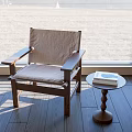 Comfortable Wooden Frame Leisure Chair With Beige Cushion By Window And Small Round Table