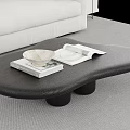 Unique Black Coffee Table with Books and Decorative Bowl in Modern Living Room Setting