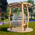 Wooden Spherical Hanging Chair In Outdoor Garden With Green Plants And Flower Beds On Lawn