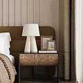 Patterned Bedside Table With White Lamp Photo Frames And Books Against Textured Wallpaper In Bedroom