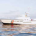 U.S. Coast Guard White Yacht Sailing On Calm Sea With Water Reflection Under Cloudy Sky