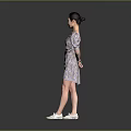 Woman In Floral Print Puffed Sleeve Dress With White Shoes Standing Against Simple Gray Background
