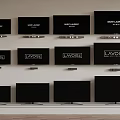 Multiple TVs of Various Sizes Mounted on Wall with LAVOISE and BASS LAUNDRY Screens