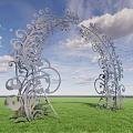 Silver Arched Gate With Intricate Scroll Designs Against Green Grass And Blue Sky