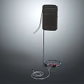 Black Speaker on Stand with Wired Headphones and Audio Cables