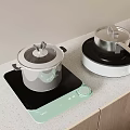 Cooking Pots On Induction Cooktop And Portable Stove With Light Countertop And Wooden Cabinets