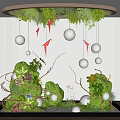 Indoor Landscape Featuring Circular Greenery Canopy Hanging Silver Spheres Red Origami Cranes And Ground Plants