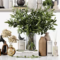 Elegant Ornamental Decor Arrangement With Green Plants Vases Candles Books And Decorative Sculptures