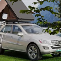 Stunning Mountain Lake Scenery With Silver SUV Roof Tent On Grassland