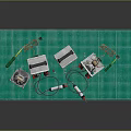 Laboratory Equipment Setup on Green Mat with Tools Wires and Small Metal Components