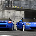 Two Blue Convertible Sports Cars Parked Near Concrete Structure And Tunnel Entrance