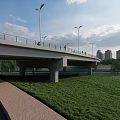 Modern Bridge Over River With Tall Buildings Green Grass And Blue Sky