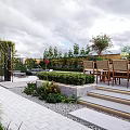 Courtyard Garden With Wooden Dining Table Chairs Green Bushes And Stone Steps