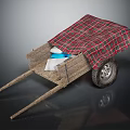 Wooden Wheelbarrow Covered With Red And Black Plaid Cloth And Blue White Items Inside