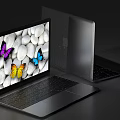 Open Silver Laptop With Colorful Butterflies And White Pebbles Screen Display Alongside Closed Laptop