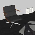 Black Leisure Chair with Wooden Armrests and Metal Legs on Dark Floor with Open Book