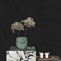 Ceramic Vase with White Dried Flowers on Marble Stand Against Dark Velvet Curtain