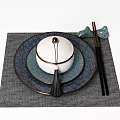 Blue Toned Tableware Set With Stacked Plates Lidded Bowl Tassel And Chopsticks On Gray Placemat