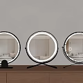 Round Lighted Mirrors With Black Silver Gold Bases On Wooden Surface