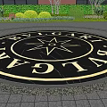 Circular Garden Ornament With Trimmed Hedges And Arched Red Brick Building Background
